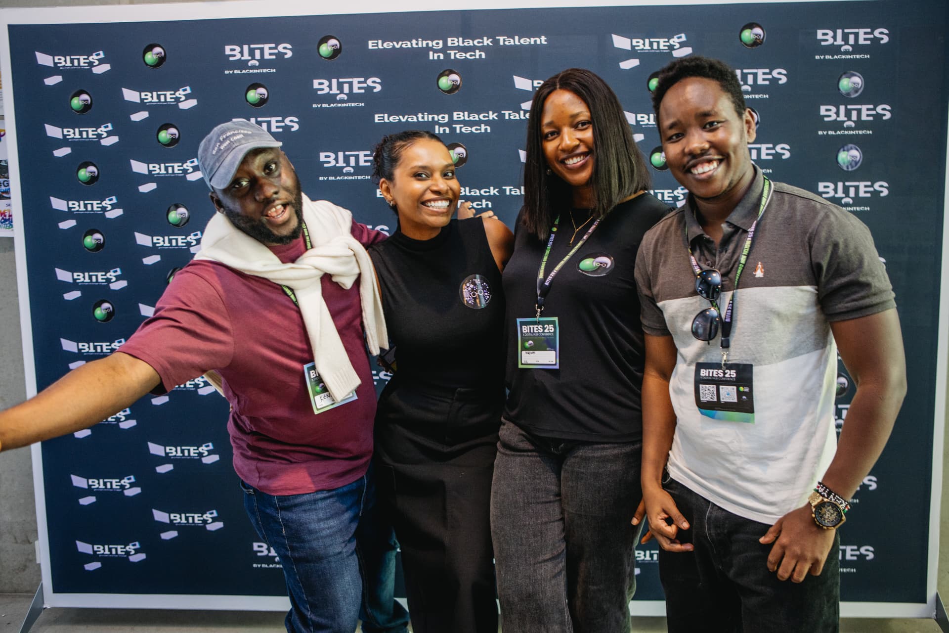 Smiling attendees posing together in front of the BITES backdrop